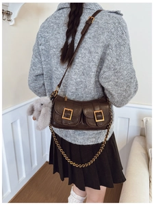 Detail view of a vintage dark coffee dumpling bag with double pockets and rabbit charm