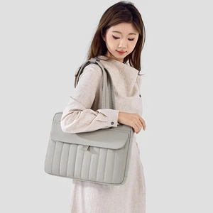 Vista dettagliata della borsa tote trapuntata grigia con strisce verticali e tracolle