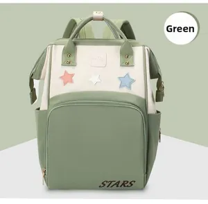 Green and beige patchwork diaper backpack with star patches and waterproof fabric detail