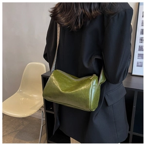 Détail du sac polochon en cuir ciré vert avec une bandoulière texturée à vagues