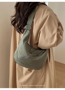 Close-up of retro green canvas hobo bag with adjustable strap and textured fabric detail
