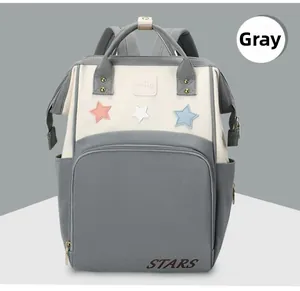 Detail view of water-resistant autumn mommy backpack featuring star patches and gray stitching