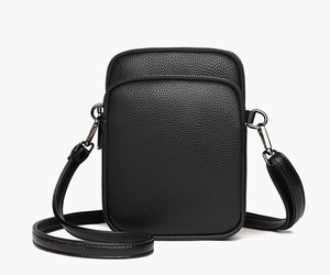 Close-up of black litchi grain leather texture and metallic gunmetal zipper details