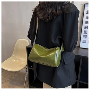 Détail du sac cylindrique vert brillant avec large bandoulière jacquard motif ethnique