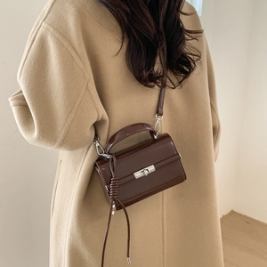 Detail of adjustable dark brown PU leather shoulder strap with silver metal buckles