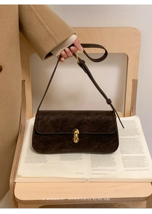 Détail d'un sac bandoulière rétro en similicuir marron foncé avec fermoir doré et bandoulière