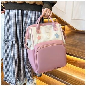 Detail of pink mommy backpack with star patches and multi-functional storage pockets