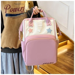 Detail view of the pink and beige patchwork backpack with decorative stars and handle