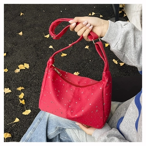 Détail du sac cabas en nylon rouge avec imprimés étoiles argentées et fermeture éclair