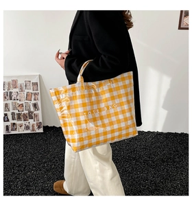 Detail of yellow checkered tote bag with waterproof coating and TOTE BAG lettering
