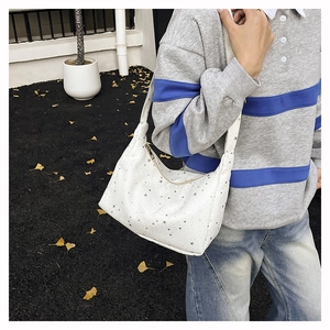 Détail du sac à bandoulière blanc avec motifs d'étoiles noires et fermeture éclair