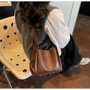 Detail of vintage brown leather tote bag with brand logo and comfortable long handles