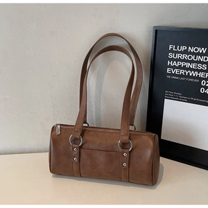 Sac polochon vintage en cuir marron avec bandoulières élégantes et détails métalliques