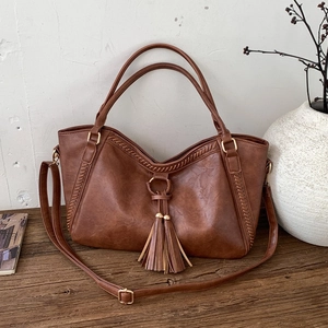 Vintage brown leather tote bag with elegant long tassels and woven stitch details