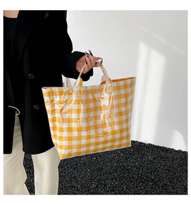 Detailed view of yellow gingham tote bag featuring white TOTE BAG text print