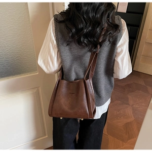 Lifestyle shot of dark brown leather tote bag with vintage texture and embossed lettering