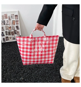 Detail shot of a red and white checkered canvas tote bag with bold TOTE BAG lettering