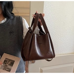 Close-up of a large coffee-colored vintage tote bag with detailed faux leather texture