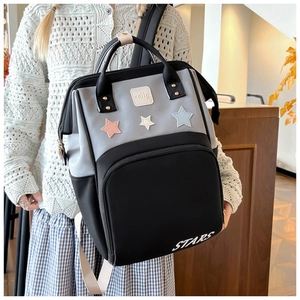 Detailed view of fashionable water-resistant backpack with three colorful star patches