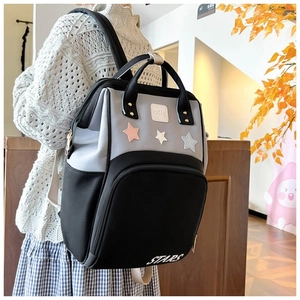 Detailed side view of a large multi-functional diaper backpack with star patches and pockets