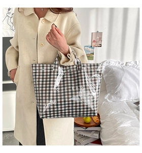 Detail of waterproof gingham tote bag featuring glossy PVC layer and TOTE BAG lettering
