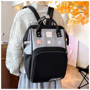 Detail of the multi-compartment diaper backpack with star patches and STARS print