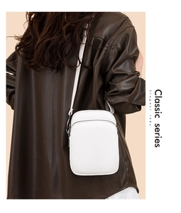 Detailed view of the white lychee grain texture and zipper on the small crossbody bag