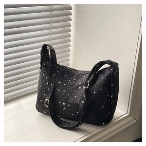 Sac fourre-tout noir à motif d'étoiles avec bandoulière réglable sur un rebord de fenêtre