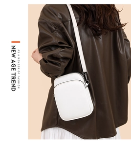 Detail showing white lychee pattern leather texture and dual zipper design on mini bag