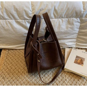 Vintage brown leather bucket bag with top handles and adjustable shoulder strap