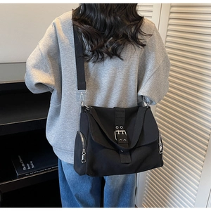Detail der schwarzen Karo-Tasche mit Silberschnalle und Seitenreißverschluss im Techwear-Stil