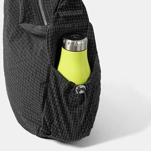 Dettaglio della tasca laterale con coulisse e una borraccia verde neon inserita nella borsa
