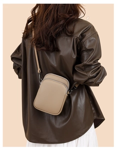 Detailed macro view of khaki lychee grain leather mini crossbody bag with double zippers