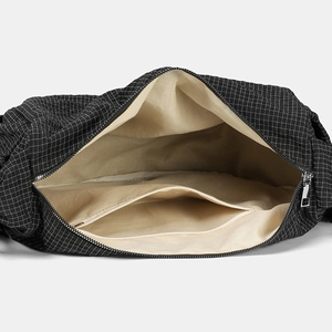 Vista dettagliata dell'interno della borsa in nylon a scacchi con fodera beige e tasca zip