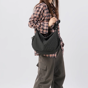 Grande borsa a mezzaluna in nylon a scacchi neri con tracolla a fiocco su modella