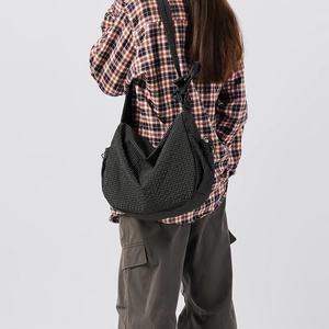 Dettaglio della borsa hobo in nylon a quadri neri con design a nodo sulla tracolla