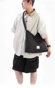 Dettaglio di una borsa tote in nylon nera capiente con patta geometrica a triangolo