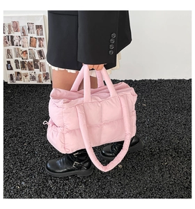 Chic pink quilted puffer tote bag with side drawstring detail styled by fashion model
