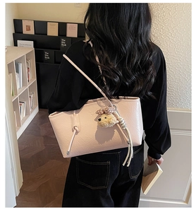 Borsa tote rosa in similpelle con trama a pieghe e ciondolo a cucciolo indossata dal modello