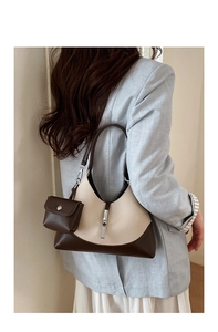 Close-up of dual-tone cream and brown leather bucket bag with silver metal buckle detail