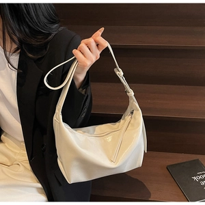 Detail of soft white vegan leather hobo bag with adjustable strap and metal zipper
