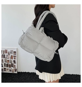 Detailed back view of a grey quilted down shoulder bag with square stitching patterns