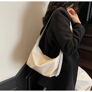 Minimalist creamy white hobo shoulder bag with smooth texture shown on a model