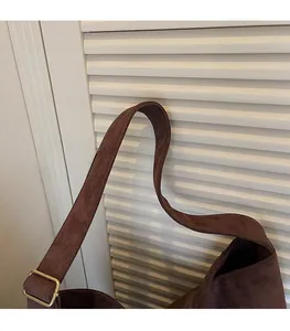 Detail of adjustable brown suede tote shoulder strap with premium gold metal buckle