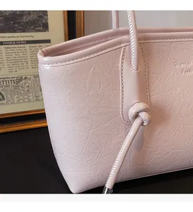 Vista dettagliata della borsa tote rosa con texture in ecopelle e design del manico annodato