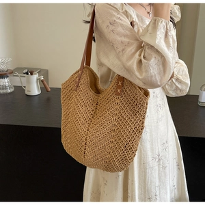 Close-up of woven shoulder bag showing crochet texture and brown leather strap stitching