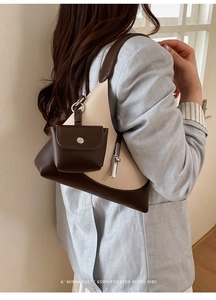 Detailed view of retro color-block dumpling bag with textured leather and mini coin purse