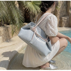 Vue détaillée du grand sac cabas en cuir bleu clair avec texture souple et anses