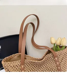Detail of woven beach tote bag featuring leather shoulder strap and zip closure