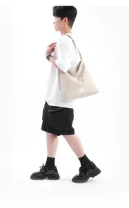 Dettaglio della borsa tote beige con cuciture geometriche ed etichetta in tessuto laterale